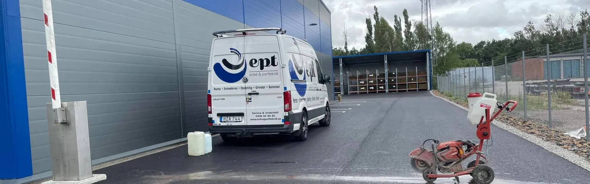 Servicebil från Entré och Portteknik vid en bom utanför en lagerbyggnad