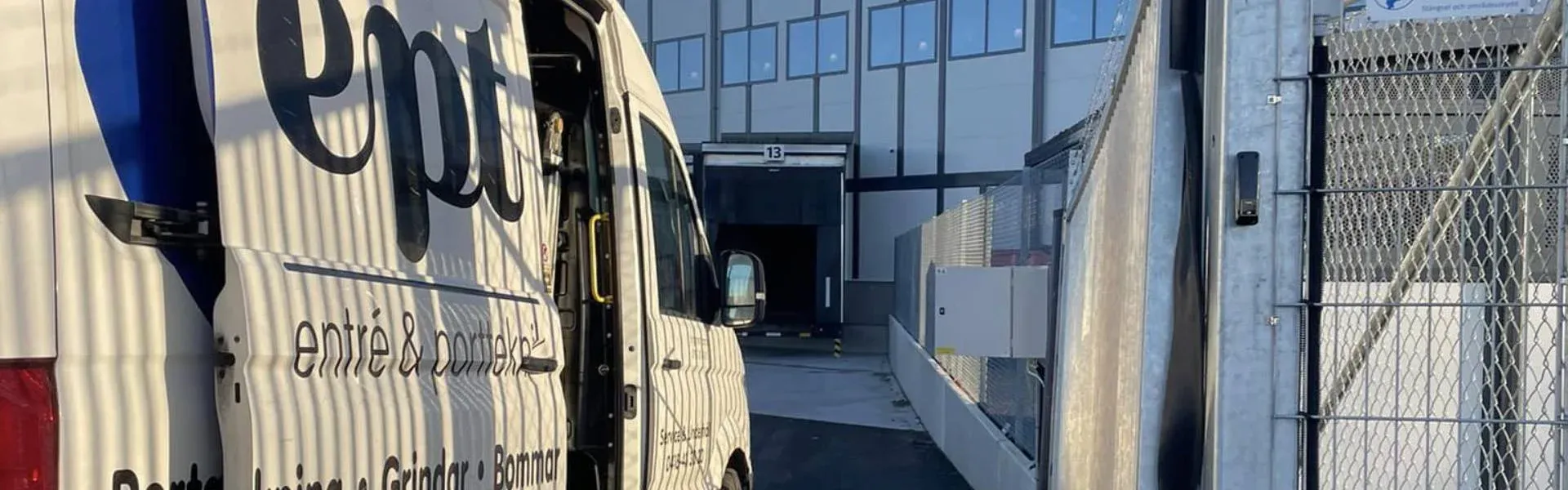 Servicebil från Entré och Portteknik vid en grind framför en lastbrygga